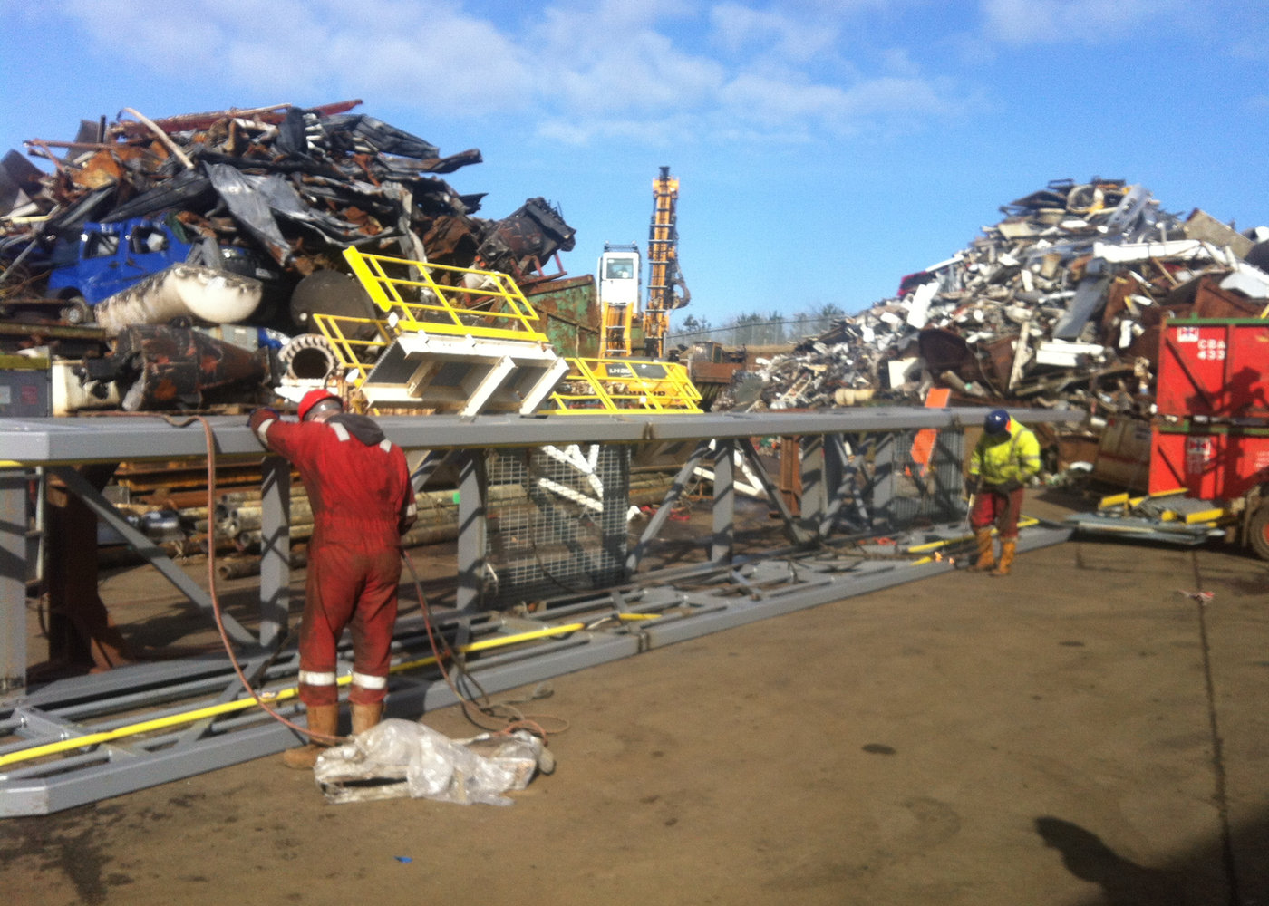 Crew processing a large steel structure into recyclable sections