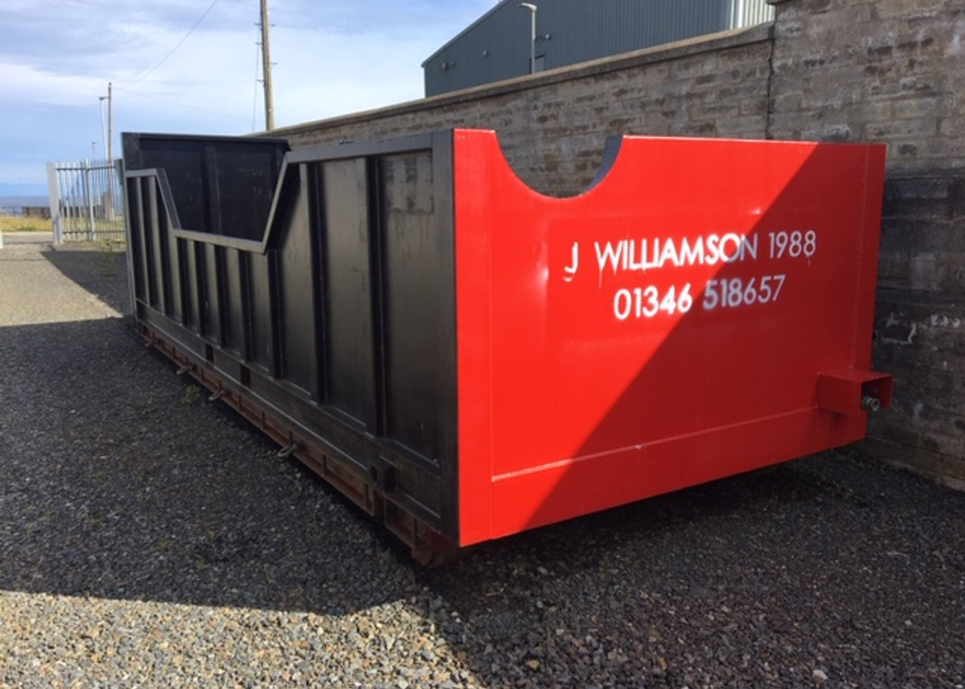 Red J Williamson 1988 branded roll on roll off skip