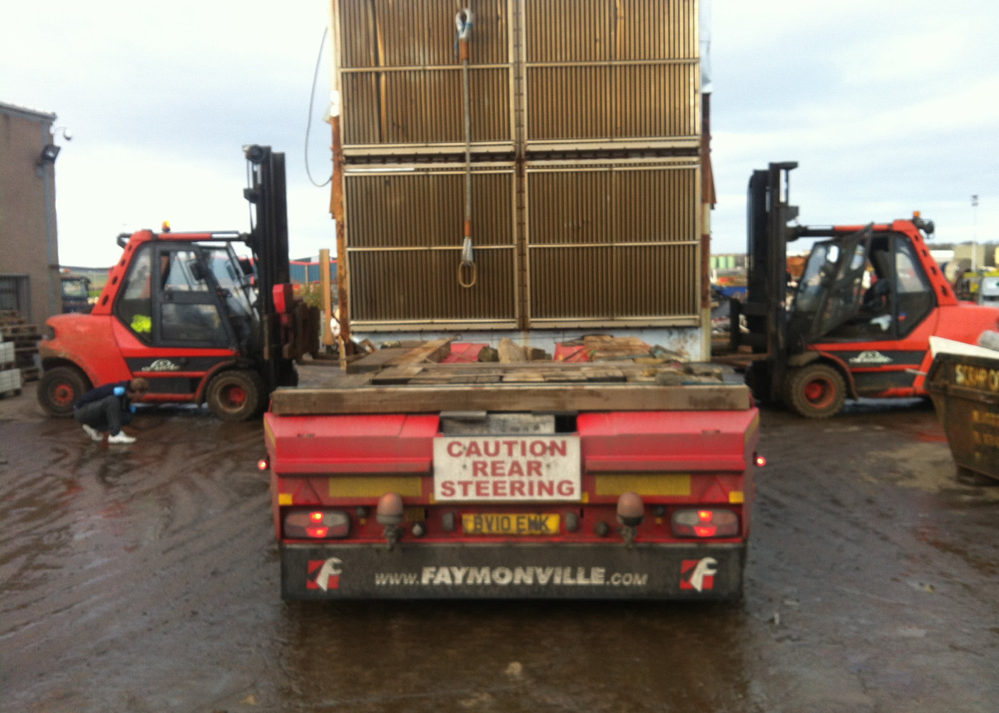 Forklifts offloading a reusable oversized steel unit from a heavy haulage trailer