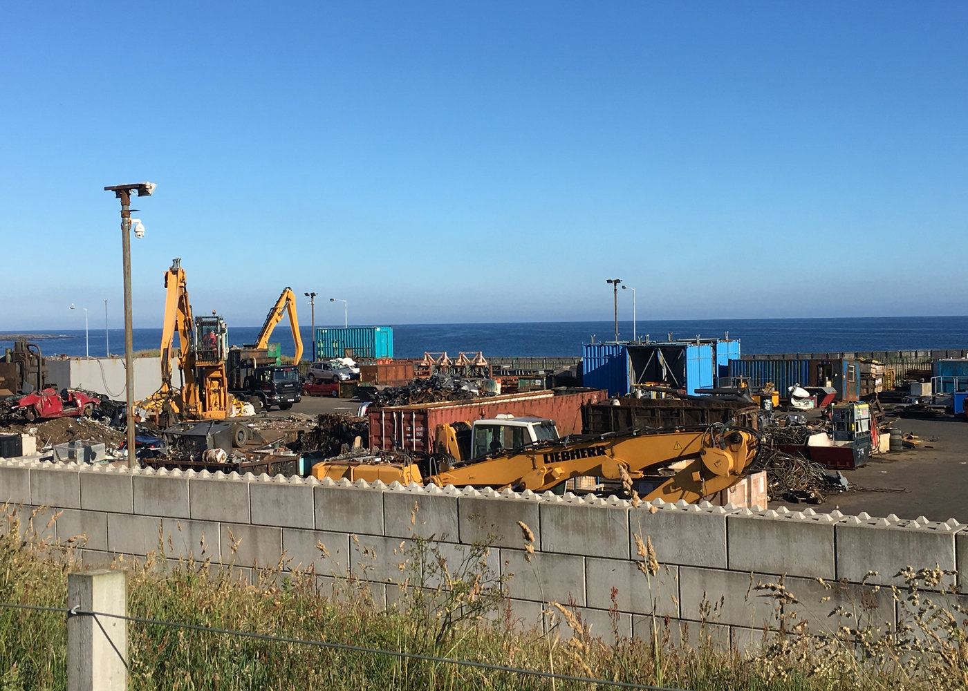 The Fraserburgh yard beside the sea with cranes and sorted scrap